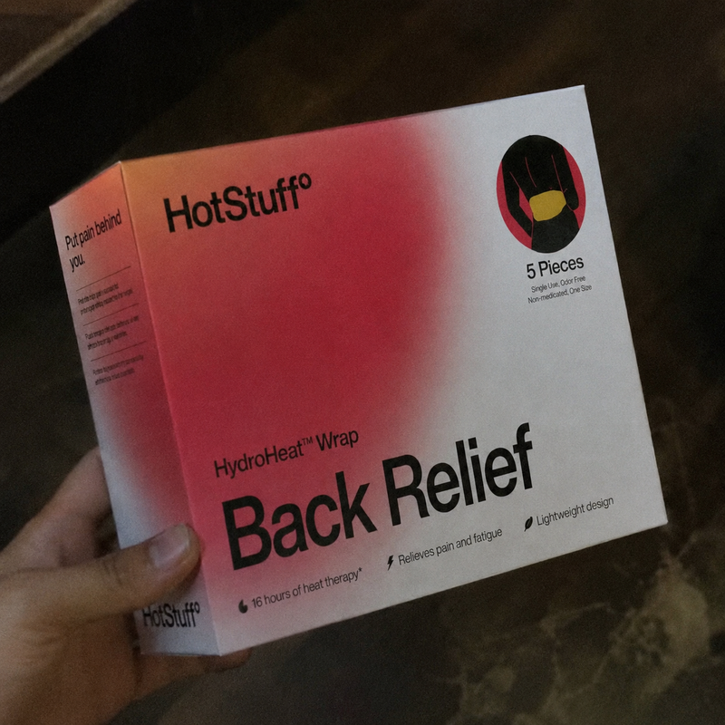 A hand holding the HotStuff Back Relief box indoors