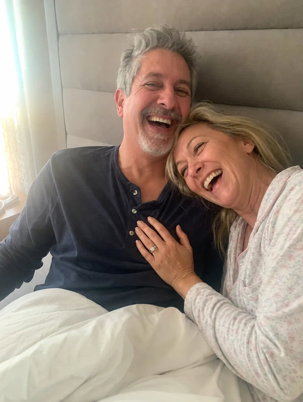 A couple laughing together in bed in the morning