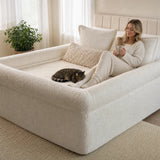 Woman relaxing with coffee and a cat inside The Cocoon bordered nest sheet
